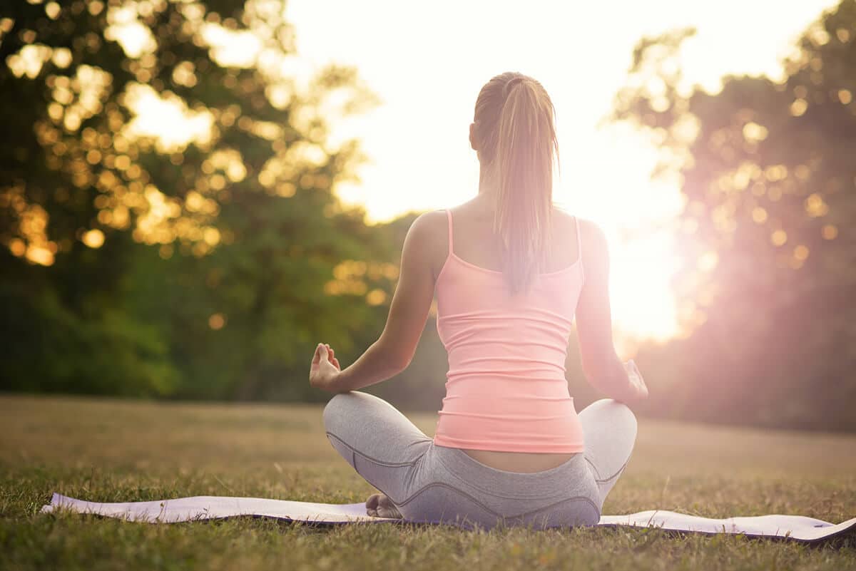Coach leading a sunrise yoga session in a sunlit park